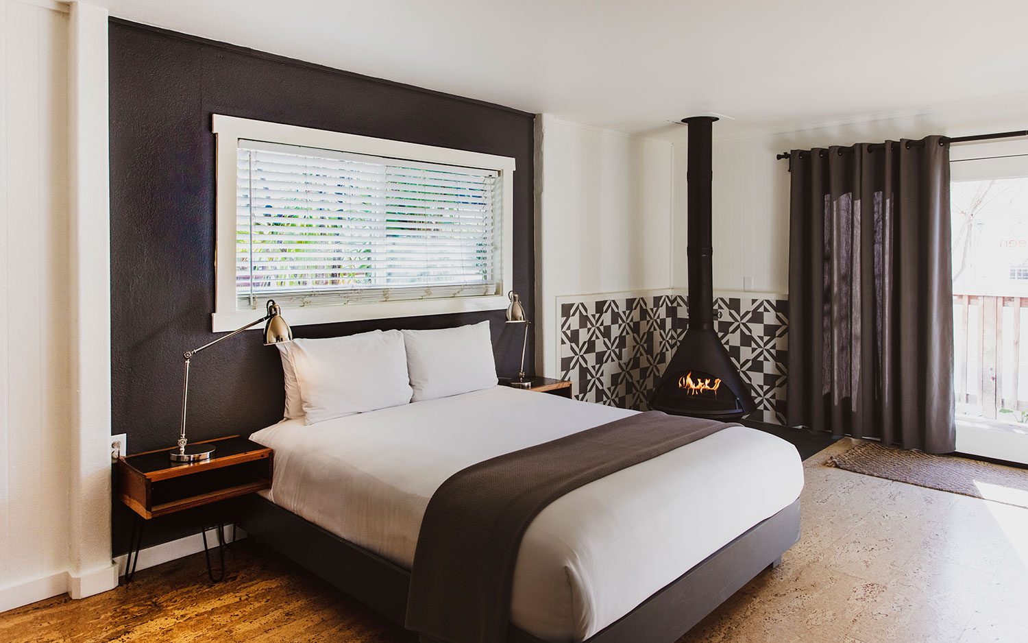 boon hotel + spa. room interior. bed with fireplace.